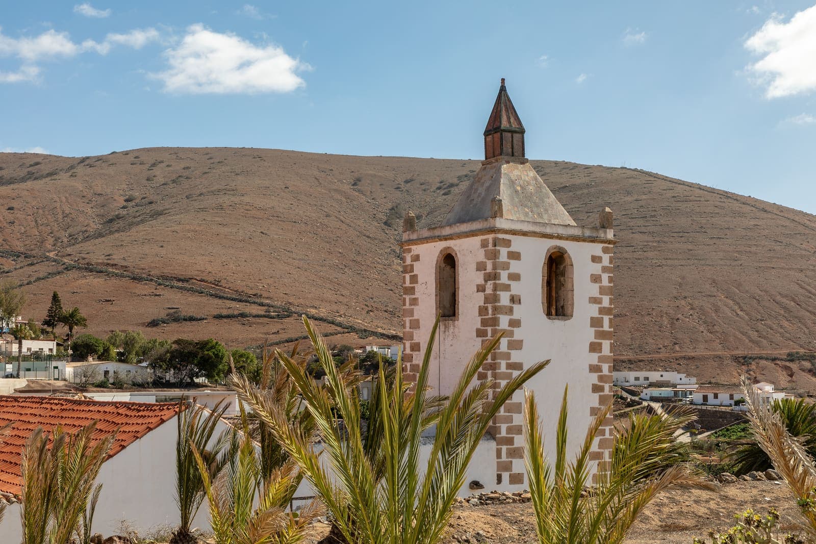 Il campanile della chiesa di Santa María a Betancuria, fra le palme e le colline dell'interno