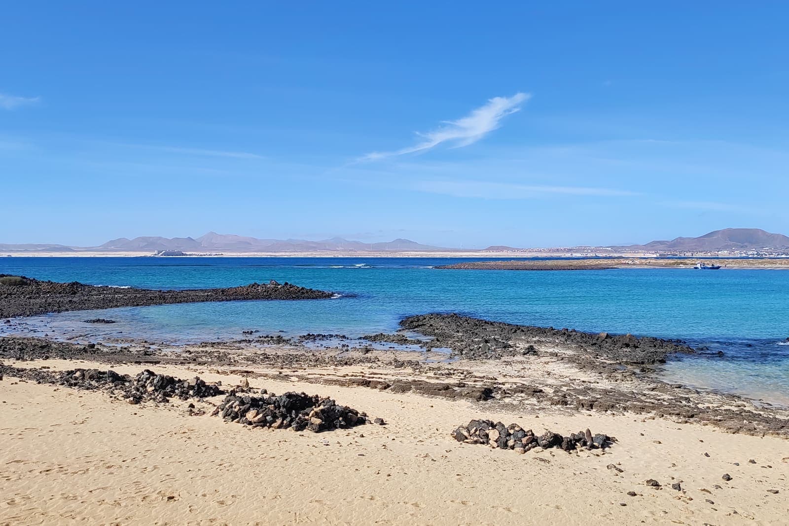 Una spiaggia dell'isolotto di Lobos, acqua bassa e scogli di lava