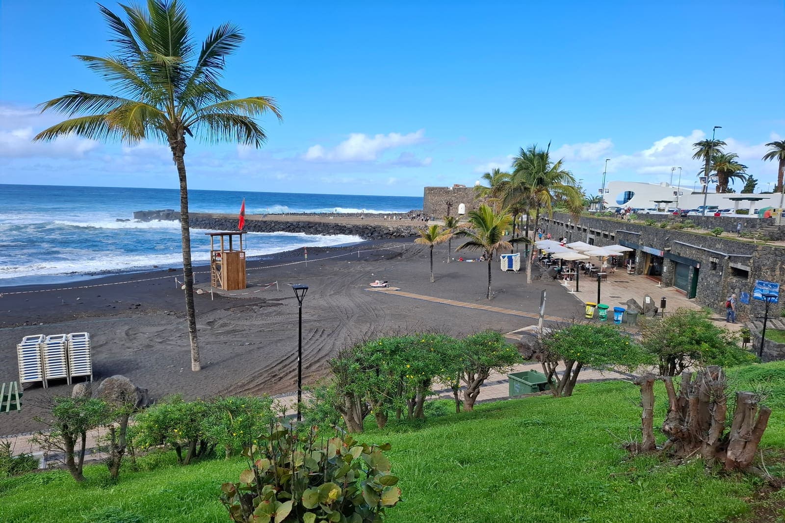 Playa Jardín a Puerto de la Cruz: la sabbia nera, le palme e il Castillo de San Felipe accanto al mare