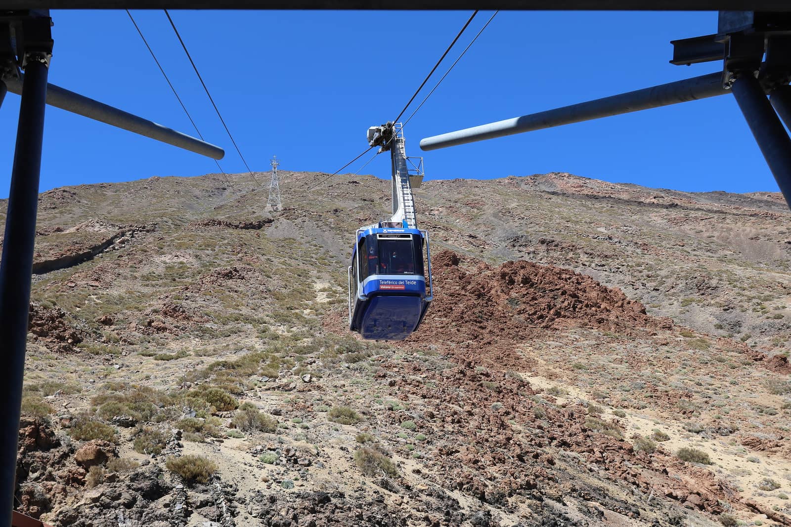 La cabina della funivia del Teide che sale sul fianco del vulcano, sotto il cielo blu