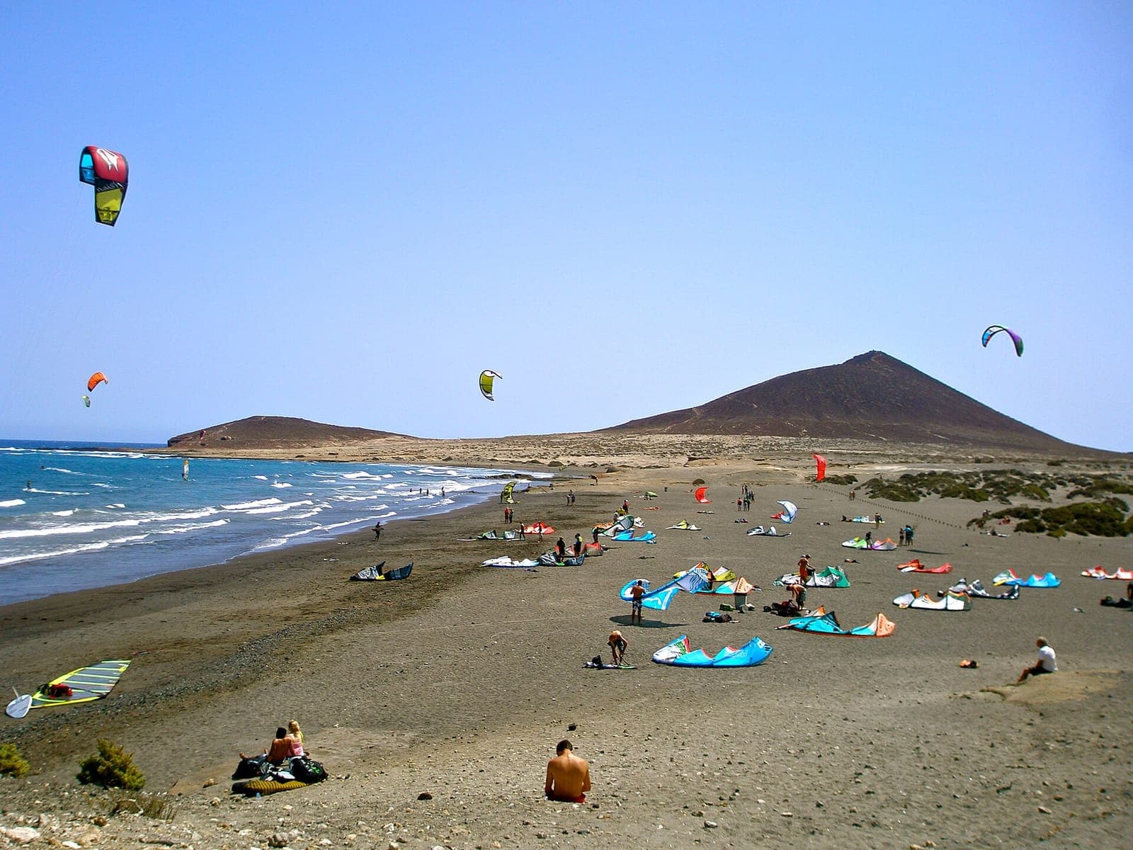 La spiaggia di El Médano con Montaña Roja sullo sfondo e i kite nel cielo